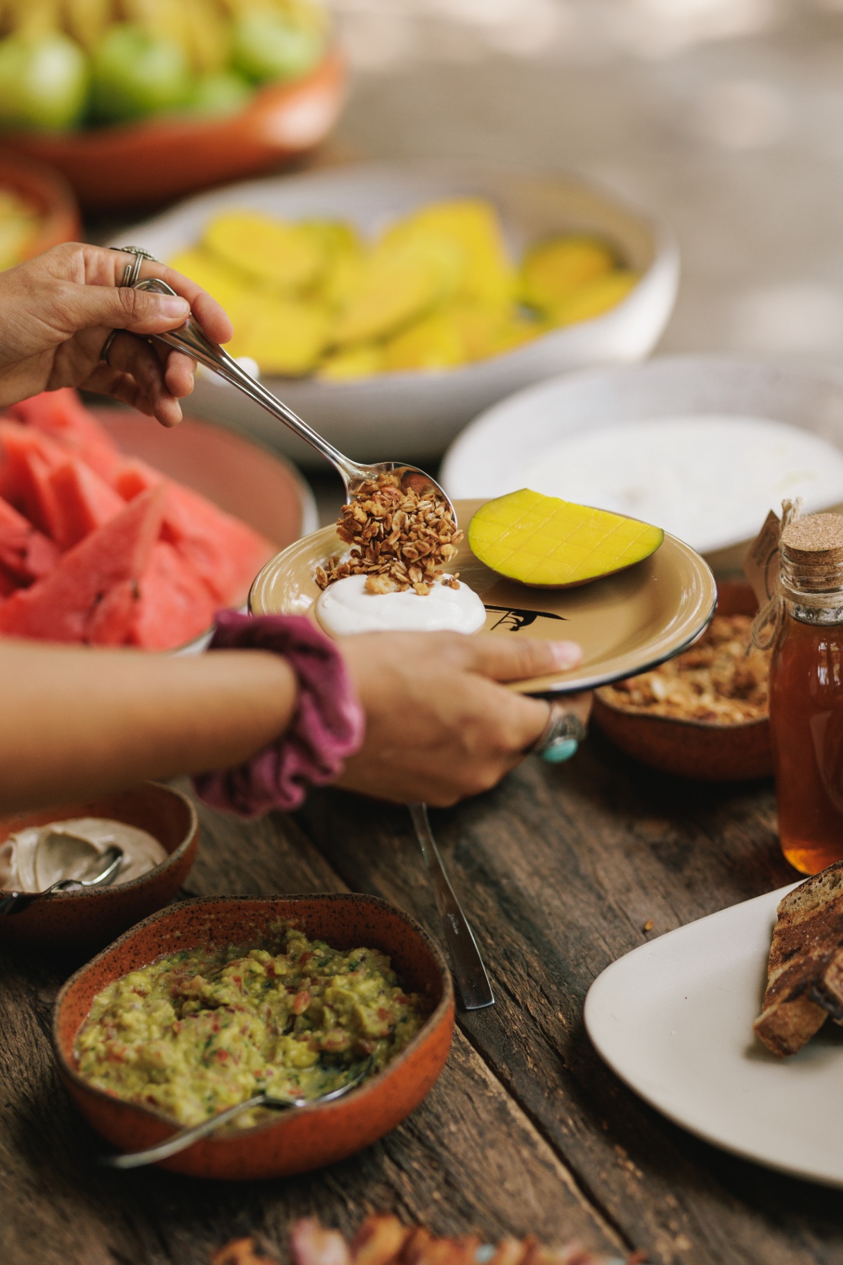Café da manhã com granola, manga e frutas frescas servido no Retiro Bálsamo